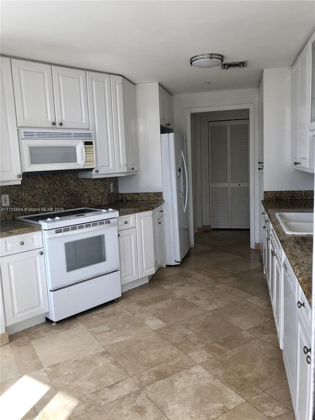 kitchen featuring white cabinets, backsplash, white appliances, and sink