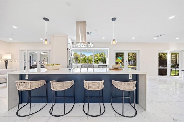 kitchen featuring a large island, hanging light fixtures, island range hood, and french doors