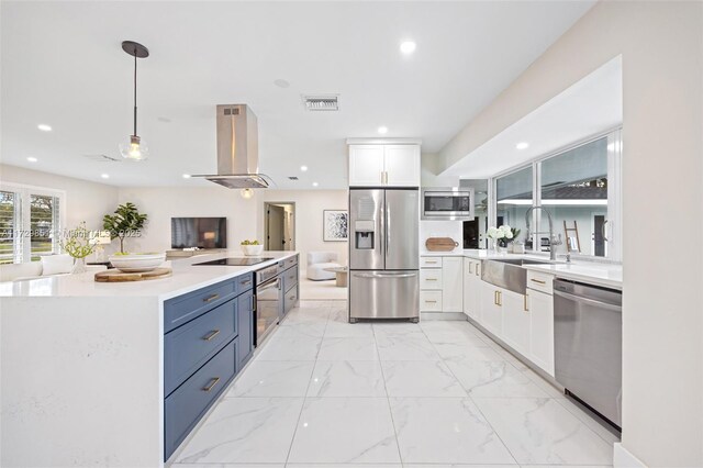 kitchen with sink, stainless steel appliances, island range hood, white cabinets, and decorative light fixtures