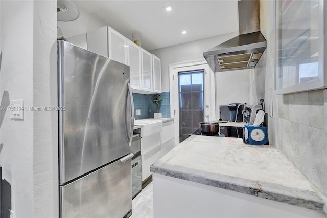 1551 Michigan Ave Unit 6, Miami Beach, FL 33139 - kitchen with freestanding refrigerator, glass insert cabinets, wall chimney exhaust hood, white cabinets, and backsplash