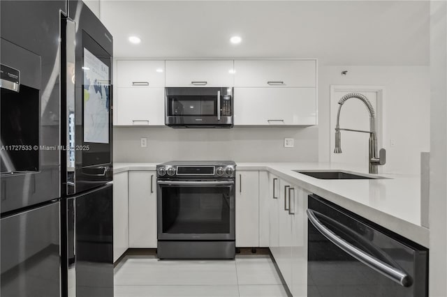 kitchen with sink, white cabinetry, light tile patterned floors, and stainless steel appliances