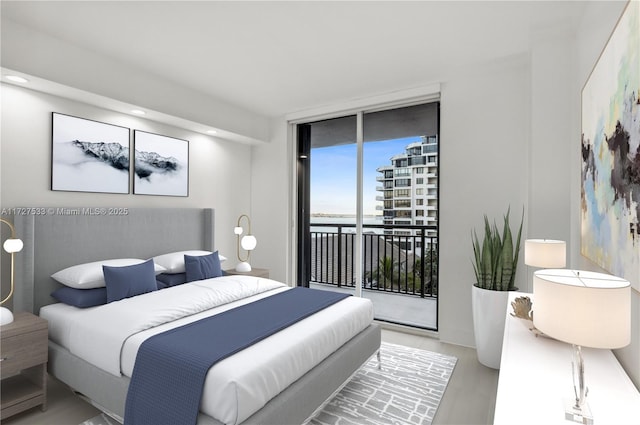 bedroom featuring hardwood / wood-style flooring, a wall of windows, and access to outside