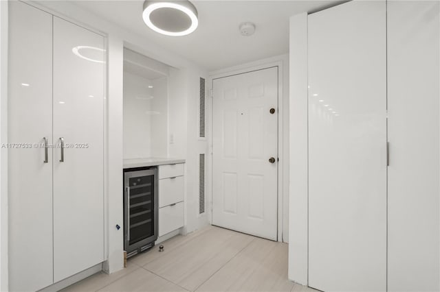 hallway featuring light tile patterned flooring and beverage cooler