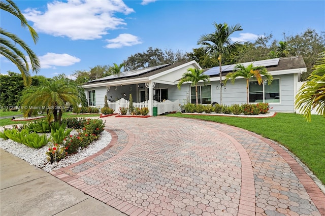 ranch-style home with solar panels and a porch