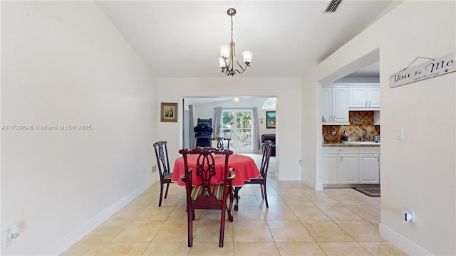 tiled dining room with an inviting chandelier