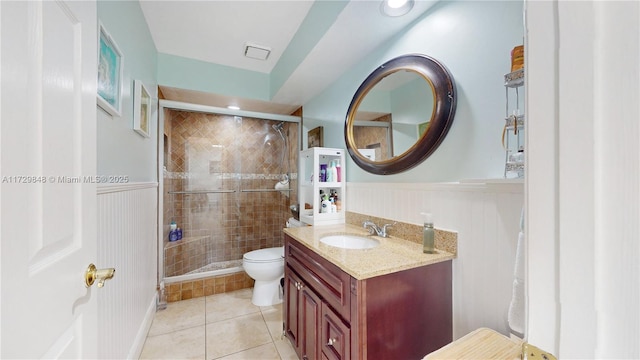 bathroom featuring vanity, tile patterned floors, toilet, and walk in shower