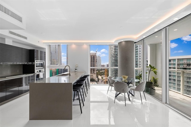 interior space featuring sink, a wealth of natural light, light tile patterned floors, and floor to ceiling windows