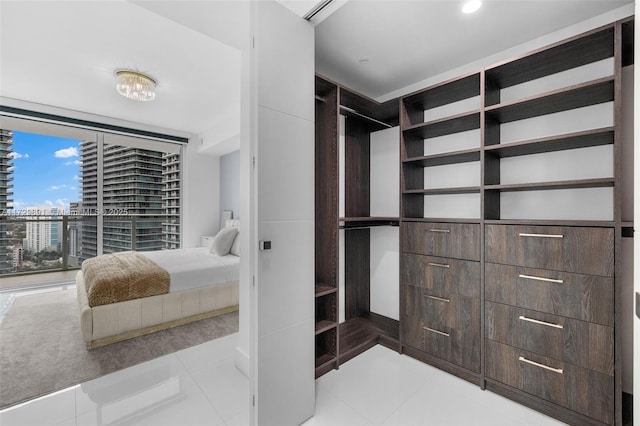 walk in closet with light tile patterned floors