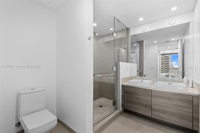 bathroom featuring a shower with shower door, toilet, vanity, and tile patterned flooring