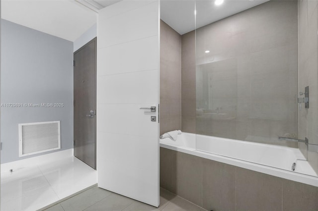 bathroom with tiled shower / bath combo and tile patterned flooring