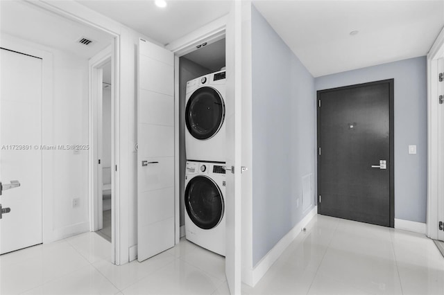 washroom featuring light tile patterned floors and stacked washer / dryer