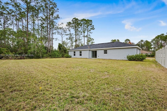 rear view of property featuring a yard