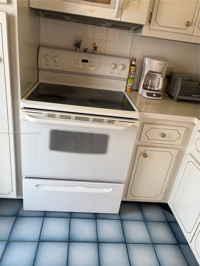 kitchen featuring white cabinetry, decorative backsplash, and white range with electric stovetop