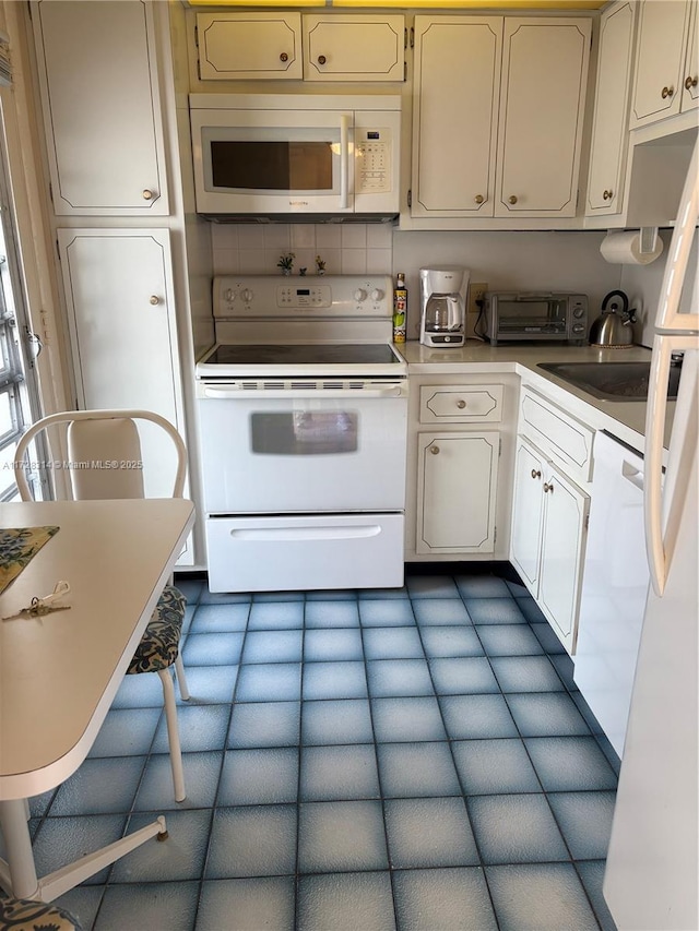 kitchen featuring white appliances and sink