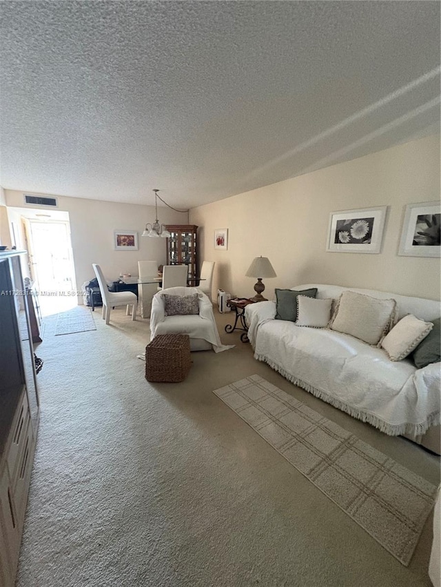 carpeted living room featuring a textured ceiling