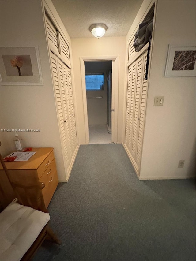 hall featuring mail boxes, carpet floors, and a textured ceiling