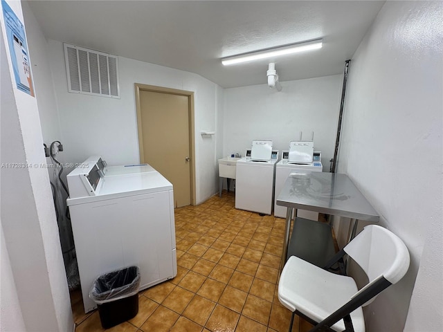 laundry area with sink, washing machine and clothes dryer, and tile patterned floors