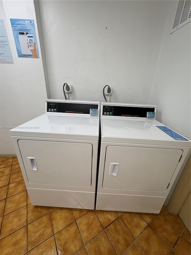 clothes washing area featuring washer and clothes dryer and tile patterned flooring