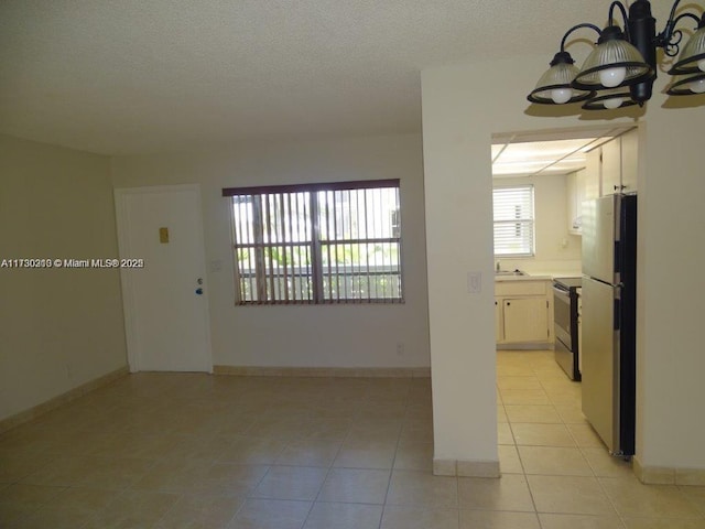 interior space featuring sink, an inviting chandelier, and light tile patterned flooring