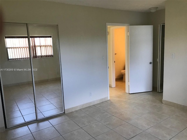 unfurnished bedroom featuring a closet and light tile patterned flooring