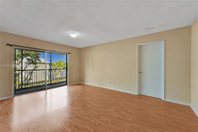 empty room featuring a textured ceiling and light wood-type flooring