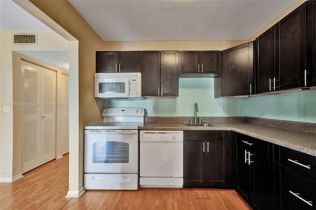 kitchen featuring sink, light wood-type flooring, dark brown cabinets, and white appliances