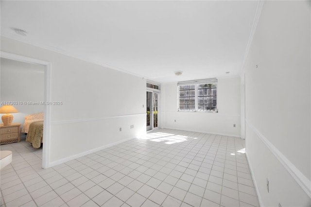 spare room with light tile patterned floors, baseboards, and crown molding