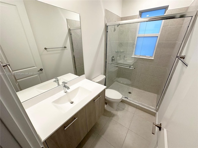 bathroom featuring toilet, tile patterned flooring, an enclosed shower, and vanity