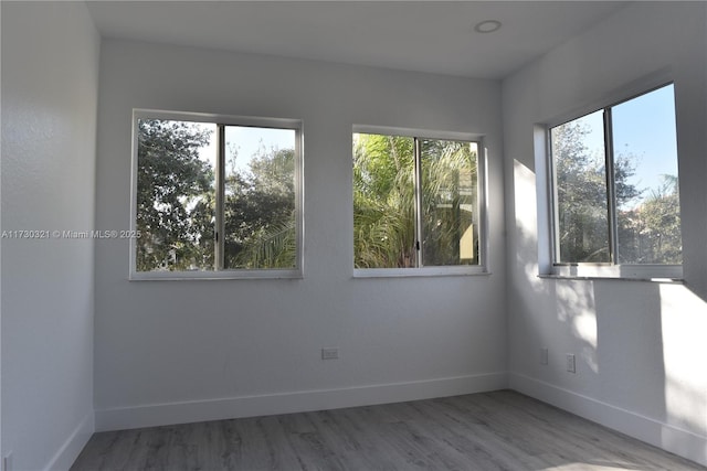 empty room featuring hardwood / wood-style flooring and a healthy amount of sunlight