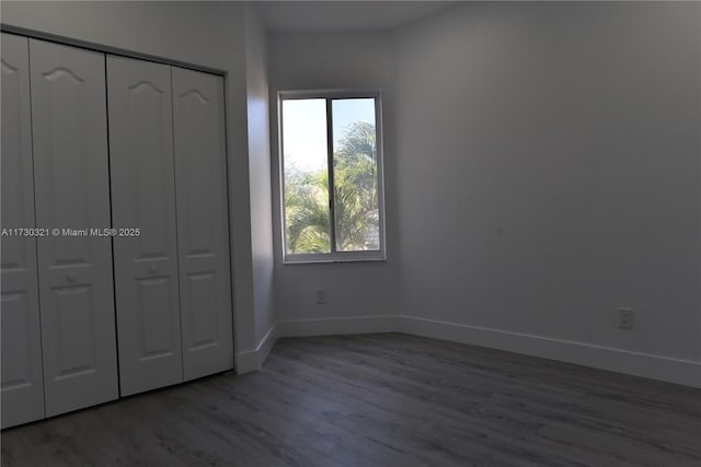 unfurnished bedroom featuring wood-type flooring and a closet