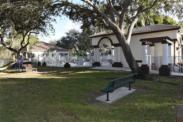 back of house with a lawn and a playground