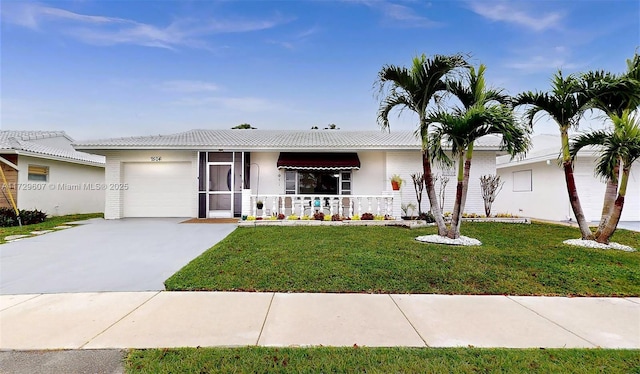 ranch-style house featuring covered porch, a front yard, and a garage