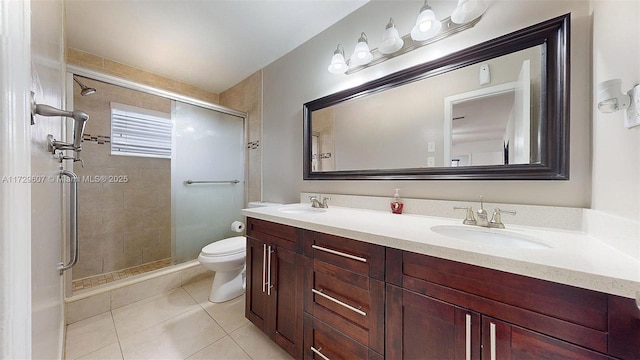 bathroom with tile patterned floors, toilet, vanity, and an enclosed shower