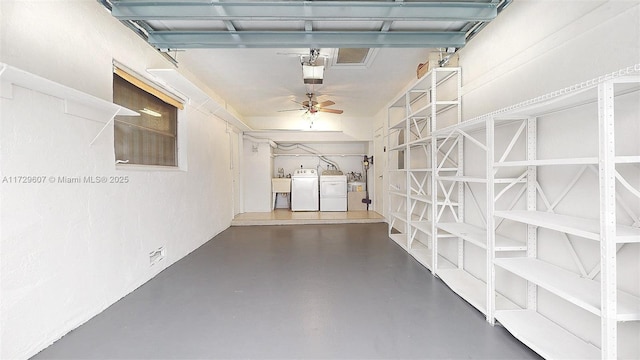 garage featuring ceiling fan, sink, washer and clothes dryer, and a garage door opener