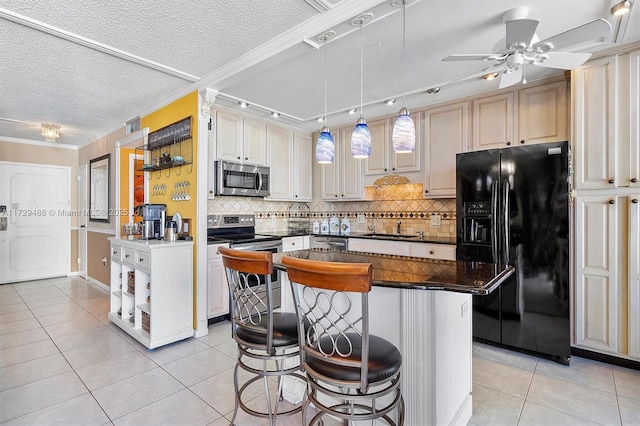 kitchen with a center island, crown molding, track lighting, a breakfast bar, and stainless steel appliances