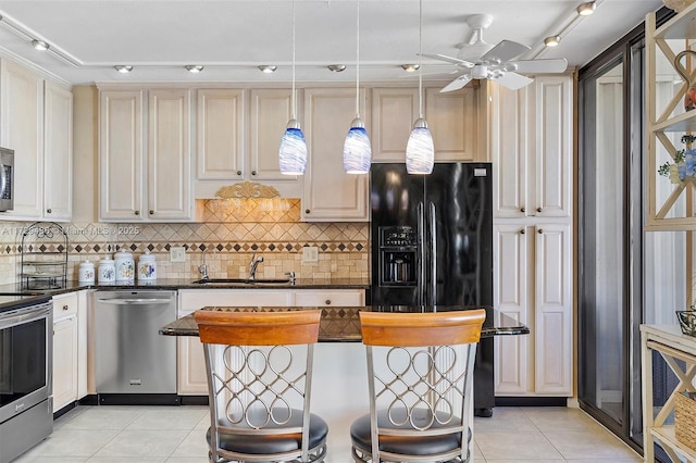 kitchen featuring appliances with stainless steel finishes, sink, hanging light fixtures, light tile patterned flooring, and ceiling fan