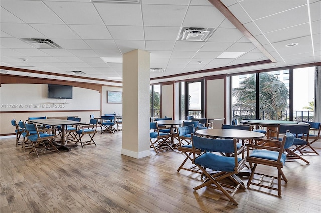 dining space with hardwood / wood-style floors and a paneled ceiling