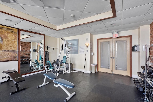 exercise room with a paneled ceiling and french doors