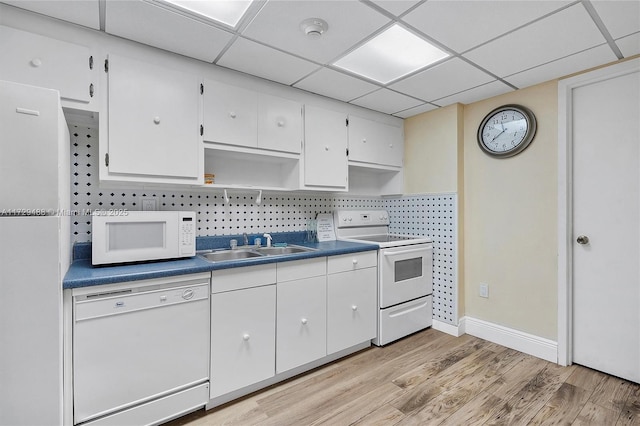 kitchen featuring white appliances, white cabinetry, decorative backsplash, sink, and a paneled ceiling