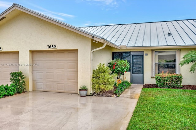 view of exterior entry with a garage and a lawn