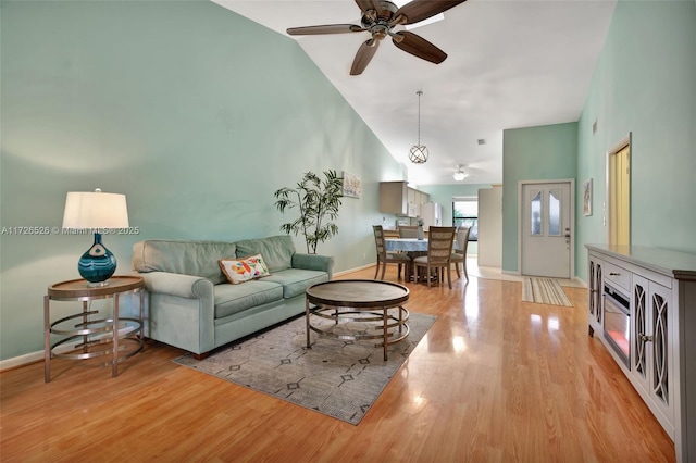 living room featuring ceiling fan, high vaulted ceiling, and light hardwood / wood-style floors