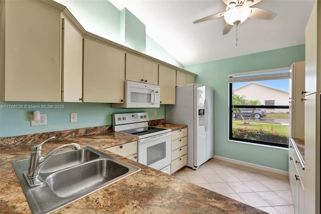 kitchen with white appliances, sink, vaulted ceiling, light tile patterned floors, and cream cabinetry