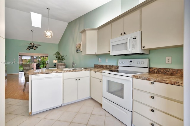 kitchen with white appliances, sink, lofted ceiling with skylight, kitchen peninsula, and pendant lighting