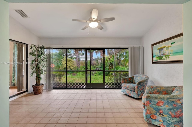 living area featuring light tile patterned floors, plenty of natural light, vaulted ceiling, and ceiling fan