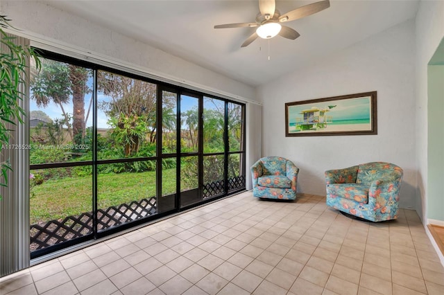 sitting room featuring ceiling fan, light tile patterned floors, and vaulted ceiling