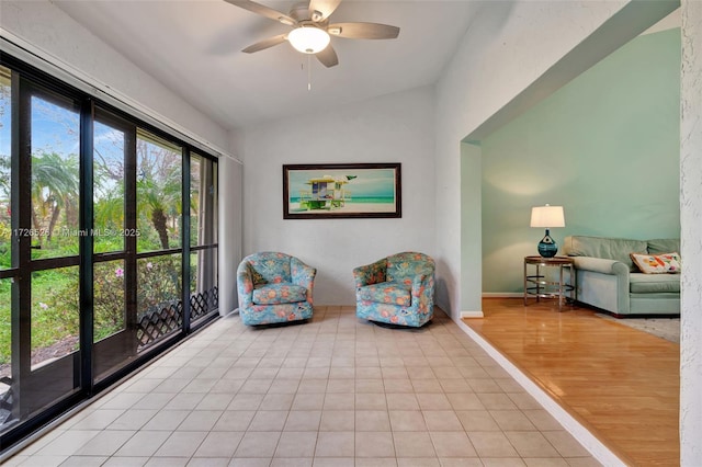 sitting room with ceiling fan, light tile patterned floors, and lofted ceiling