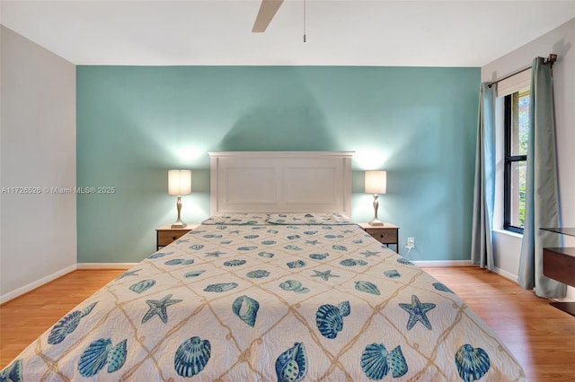 bedroom featuring ceiling fan, light hardwood / wood-style floors, and multiple windows