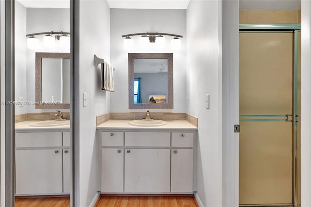 bathroom featuring vanity, walk in shower, and wood-type flooring