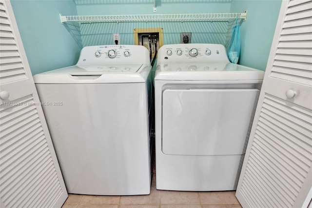 washroom featuring light tile patterned flooring and washer and dryer