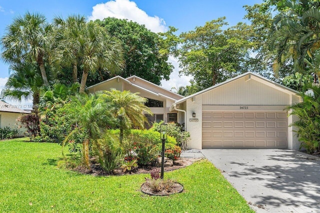 single story home featuring a garage and a front lawn